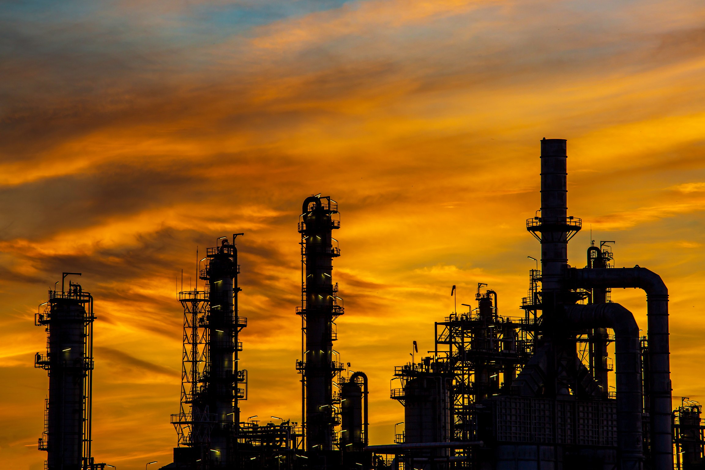 Silhouette of gas distillation of tank oil refinery plant tower